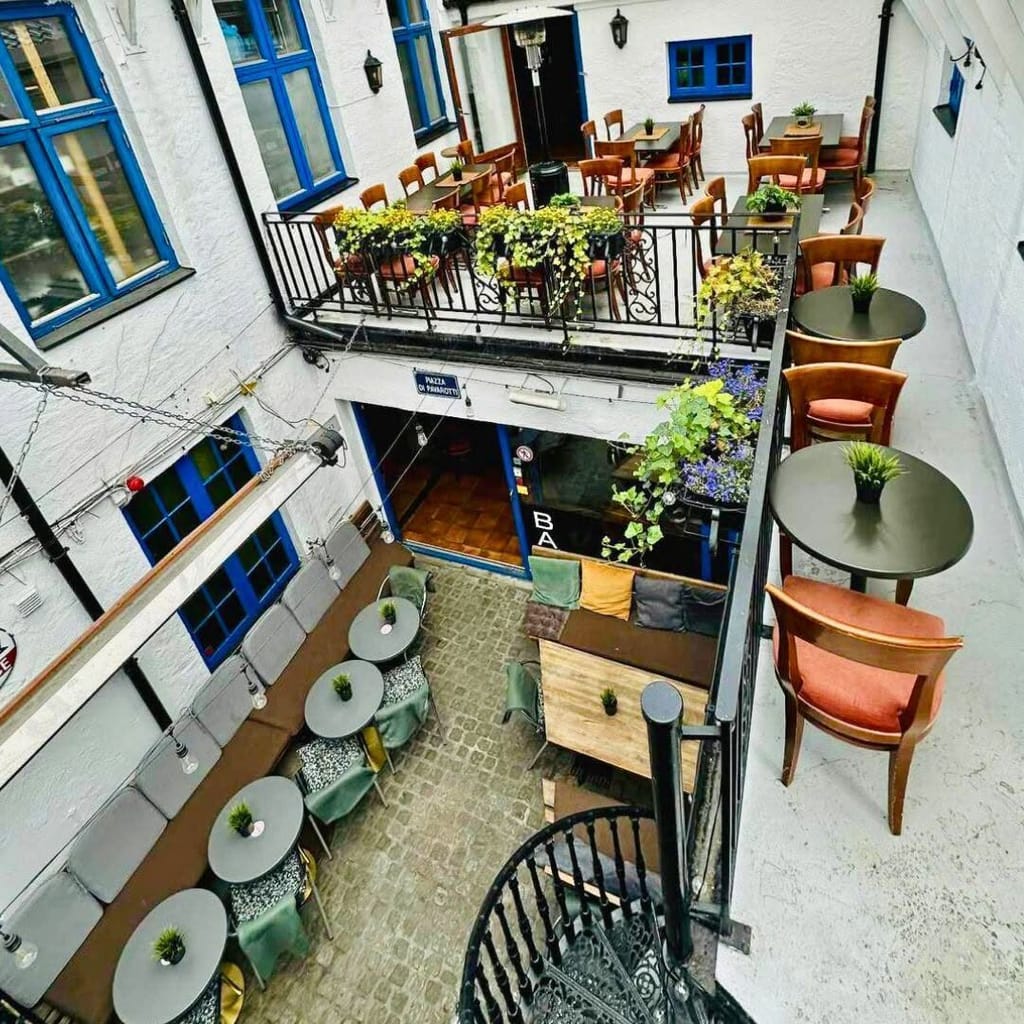 Bakgården sett ovenfra — bord, planter og balkongen